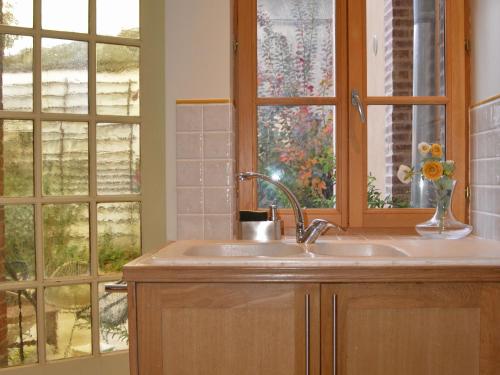 une cuisine avec un évier et une fenêtre dans l'établissement Séjournez dans une demeure écossaise historique avec salle de jeux, auberge familiale du 19ème siècle - FR-1-586-53, à Aubigny-sur-Nère