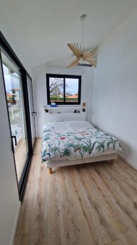 une chambre avec un lit et une fenêtre dans l'établissement Villa Pessac Bordeaux-bassin, à Pessac