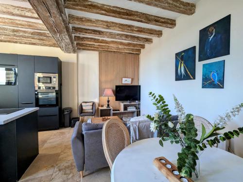 a living room with a table and a kitchen at Séjour ressourçant en Berry proche Zoo de Beauval - FR-1-591-732 in Saint-Cyran-du-Jambot