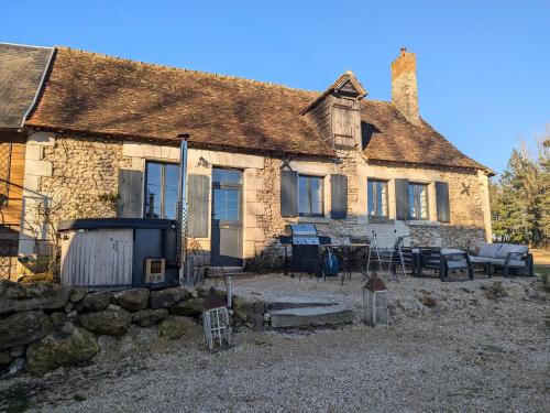 an old stone house with a table and chairs at Séjour ressourçant en Berry proche Zoo de Beauval - FR-1-591-732 in Saint-Cyran-du-Jambot