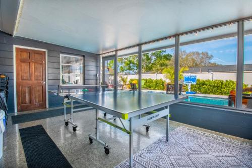 a ping pong table in a room with a large window at Lite Brite Beach Escape - Shine Brite, Relax Right! in Seminole