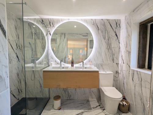 a bathroom with a sink and a mirror and a toilet at Séjour Historique au Domaine de Migny : Gîte avec Bain Nordique et Piscine - FR-1-591-731 in Saint-Cyran-du-Jambot