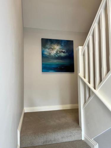 a staircase in a home with a painting on the wall at A Cozy Magical Retreat at Knightwood Oak, New Forest in Ower