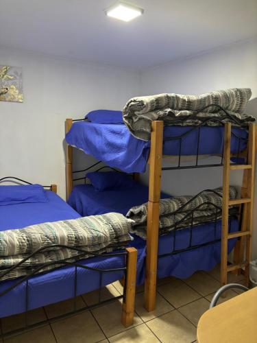 a room with two bunk beds with blue sheets at Alojamiento Puente Alto in Santiago