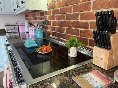 a kitchen with a counter with a bowl of fruit on it at Luxury Three Bedroom Barn Conversion in Devon in Hemyock