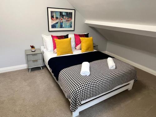 a bedroom with a large bed with colorful pillows at A Cozy Magical Retreat at Knightwood Oak, New Forest in Ower
