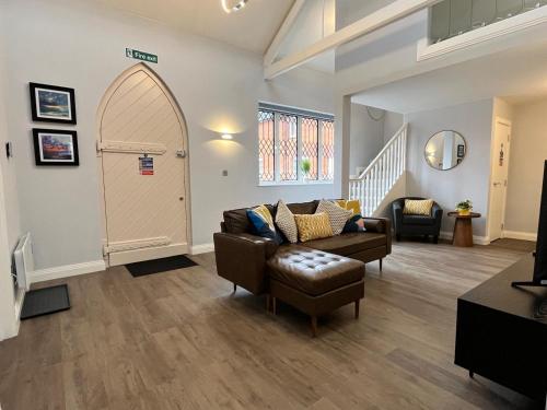 a living room with a couch and a door at A Cozy Magical Retreat at Knightwood Oak, New Forest in Ower