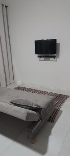 a bedroom with a bed and a flat screen tv on a wall at Moradas de Ibicuí - Apartamentos com vista para o mar in Mangaratiba