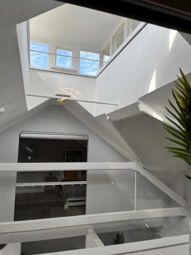 a living room with white stairs and a tv at A Cozy Magical Retreat at Knightwood Oak, New Forest in Ower