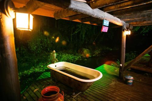an old bath tub sitting on a wooden deck at Casa da Família no Sítio Mannes in Antônio Carlos