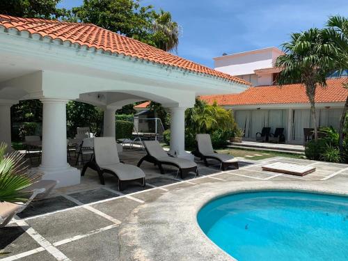 a patio with chairs and a swimming pool at Villa Zafiro in Cancún