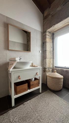 a bathroom with a white sink and a mirror at Casa do Páteo in Macieira de Alcoba