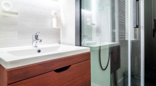 une salle de bain avec un lavabo blanc et une douche dans l'établissement Appartement aux portes de Saint-Tropez, à Saint-Tropez