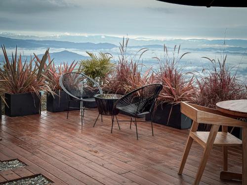 a patio with two chairs and a table and some plants at La Cima Eco Hotel in Buenavista