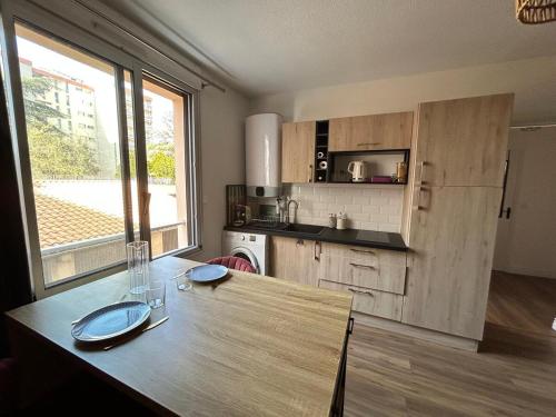 - une cuisine avec une table en bois et un comptoir dans l'établissement Appartement Montélimar, à Montélimar