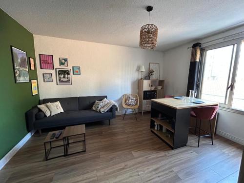 un salon avec un canapé et une table dans l'établissement Appartement Montélimar, à Montélimar
