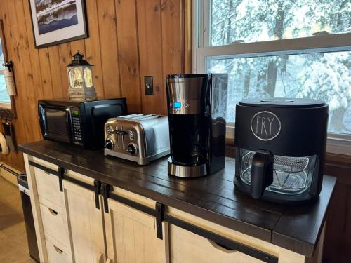 a kitchen counter with a coffee maker and a microwave at Serene Forest Lodge I Adventure Meets Serenity in Madison