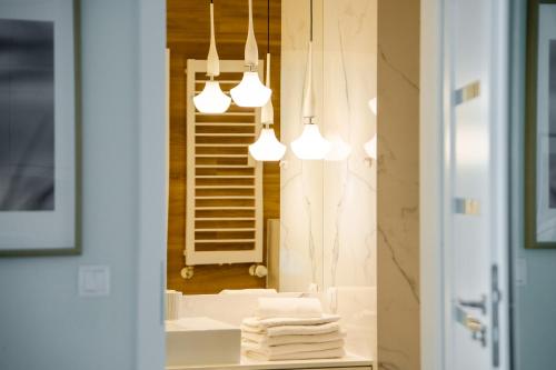 ein Badezimmer mit einem Spiegel und einem Waschbecken mit Handtüchern in der Unterkunft APT Nadmorskie - Bliżej Morza in Kołobrzeg