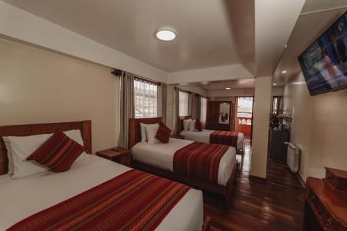 a hotel room with two beds and a flat screen tv at Quechua Hotel Cusco in Cusco