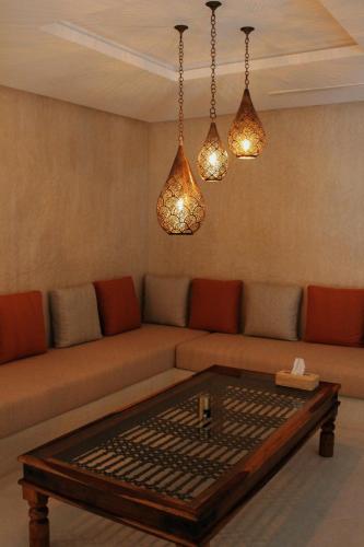 a living room with a couch with a table and lights at Maison Kenoosha Boutique Hotel & Spa in Marrakech