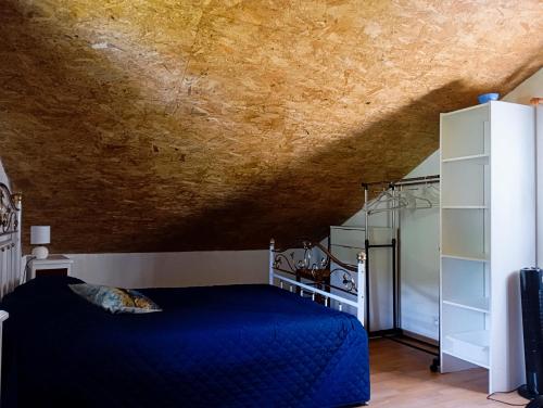 - une chambre avec un lit bleu et un plafond jaune dans l'établissement Gîte les coquelicots, à Saint-Sèbastien