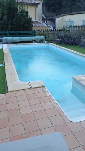 - une piscine avec une chaise dans la cour dans l'établissement Gîte les coquelicots, à Saint-Sèbastien