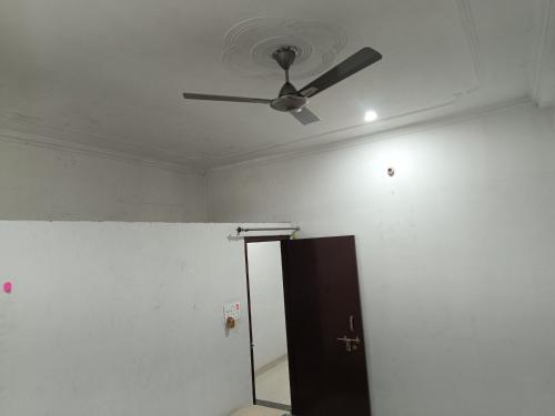 a ceiling fan in a room with a door at The Wings Home Your Home Away From Home 2 BHK in Kakarmatha
