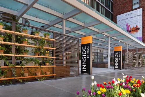 a display of flowers in a building with plants at INNSiDE by Meliá New York Nomad in New York
