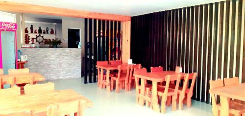 a restaurant with red tables and chairs and a fireplace at Villa Ureki in Ureki