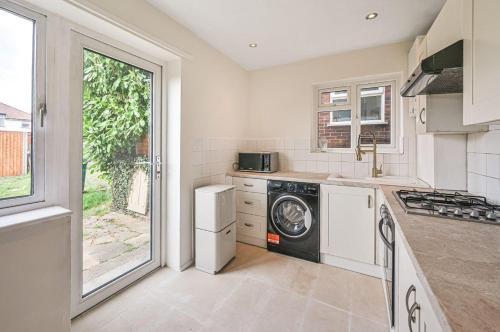 a kitchen with a washer and dryer in it at Barnet newly renovated in Barnet