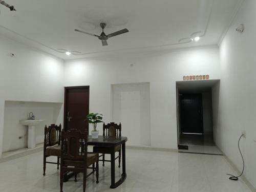 a dining room with a table and chairs and a ceiling fan at The Wings Home Your Home Away From Home 2 BHK in Kakarmatha
