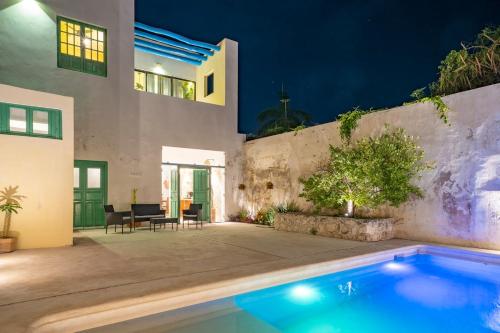 a villa with a swimming pool at night at Casa Galeria Campeche in Campeche