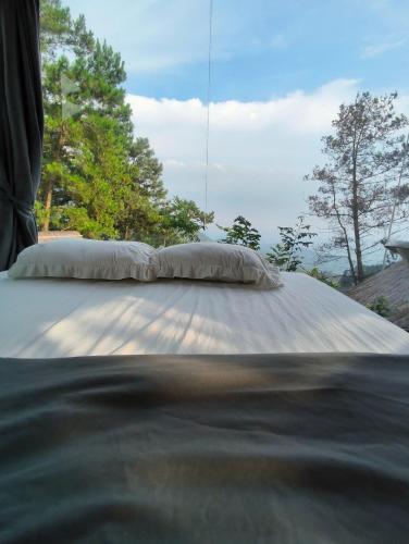 a bed with a pillow on top of it at Mimosa 226 - phòng săn mây in Tam Ðảo