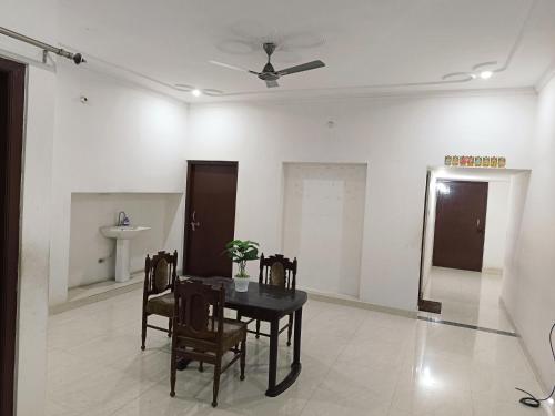 a dining room with a table and chairs and a ceiling at The Wings Home Your Home Away From Home 2 BHK in Kakarmatha