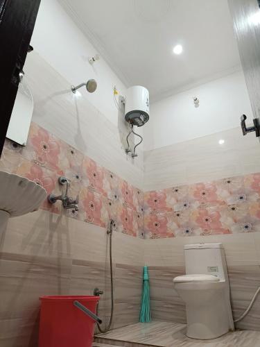 a bathroom with a shower and a toilet with flowers on the wall at The Wings Home Your Home Away From Home 2 BHK in Kakarmatha