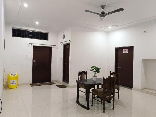 a dining room with a table and chairs and a ceiling fan at The Wings Home Your Home Away From Home 2 BHK in Kakarmatha
