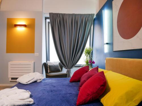 una camera da letto con letto blu e giallo con cuscini rossi di SaraHome a Bari