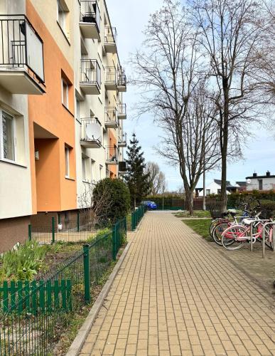 a brick sidewalk next to a building with bikes parked at Yellow Lotus in Gdańsk