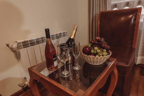 a table with two bottles of wine and a basket of fruit at Quechua Hotel Cusco in Cusco