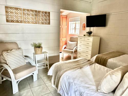 1 Schlafzimmer mit 2 Betten, einem TV und einem Stuhl in der Unterkunft The Coastal at Marina Glen Holiday Resort in Marina Beach