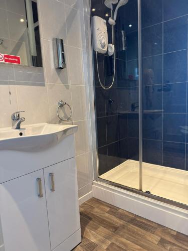 a bathroom with a shower and a sink and a shower at The Calder House Hotel in Seascale