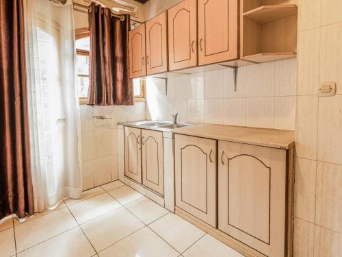 a kitchen with wooden cabinets and a sink at Hotel Saint jean Leopold Apartment in Kigali