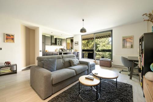 un salon avec un canapé et une table dans l'établissement Appartement Bellevue - Welkeys, à Boulogne-Billancourt