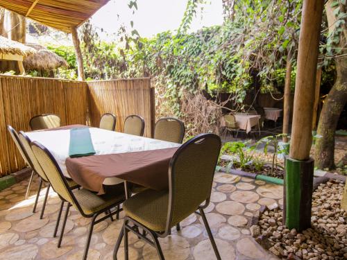 a table and chairs in a backyard with a fence at Hotel Saint jean Leopold Apartment in Kigali