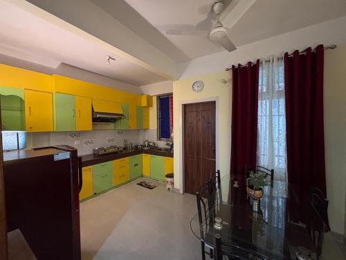 a kitchen with yellow and green cabinets at Placid Homestay in Guwahati