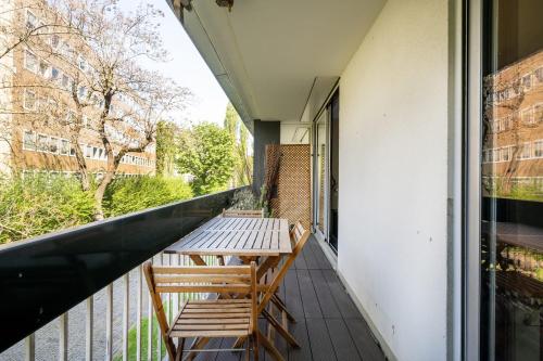 un balcon avec deux chaises et une table dans l'établissement Appartement Bellevue - Welkeys, à Boulogne-Billancourt