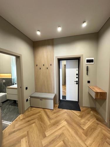 a room with a hallway with wooden floors and a mirror at ЖК Гранд хаус in Uralsk