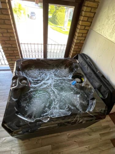 a hot tub with water in it in front of a window at TEPIĆ Garni Hotel in Temerin