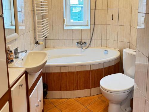 a bathroom with a tub and a toilet and a sink at Apartament Krola Stefana Batorego in Kielce