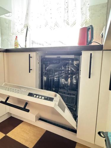 an open cabinet in a kitchen with a dishwasher at Apartament Krola Stefana Batorego in Kielce